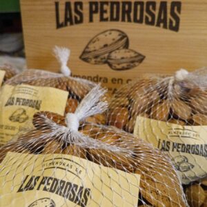 Mallas de almendra en cáscara con el cartel de Almendras de Las Pedrosas