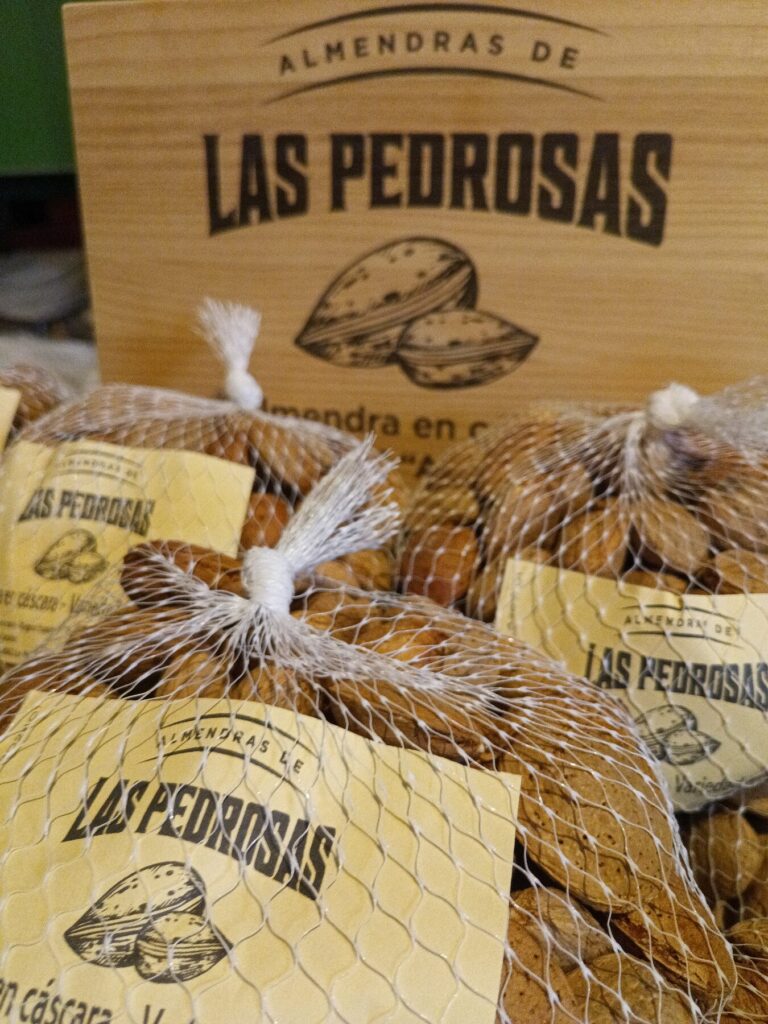 Mallas de almendra en cáscara con el cartel de Almendras de Las Pedrosas